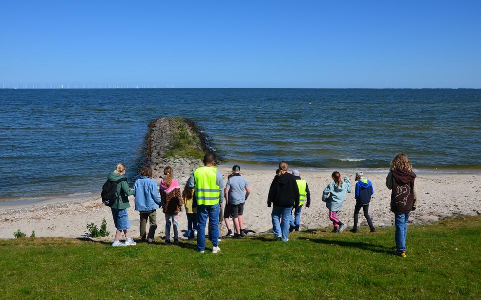 De leerlingen lopen naar de pier met grafstenen.