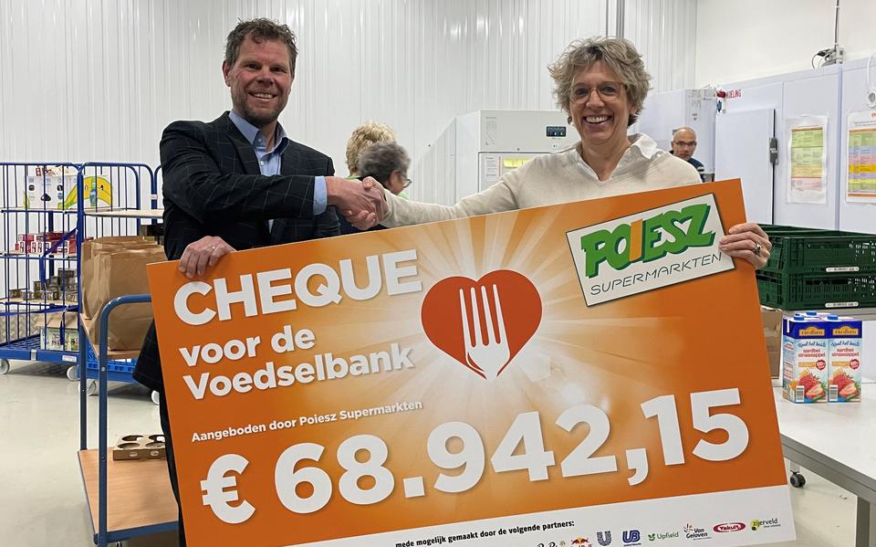 In de vestiging van de Voedselbank in Sneek overhandigt Richard Poiesz (commercieel manager Poiesz) de cheque uit aan Liliane van Heteren (Fondsenwerving Voedselbanken Nederland).